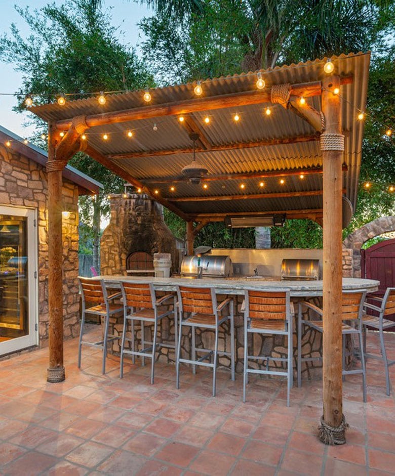 outdoor kitchen with string lights on the pergola