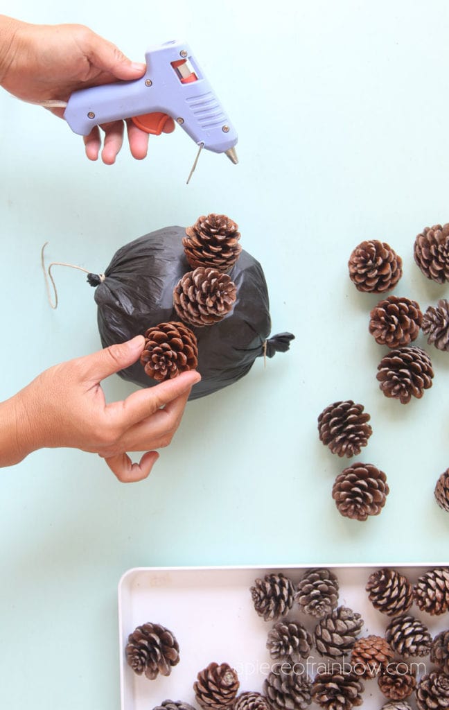 glue a ring of pine cones around the ball