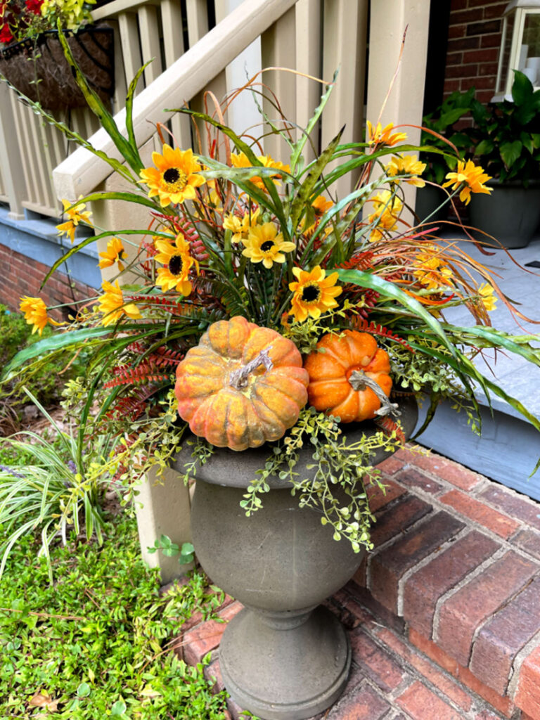 Artificial plants and faux pumpkins fall porch decor